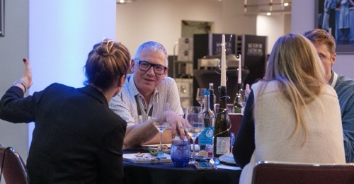 Gäste im Gespräch am Tisch beim Networking Dinner